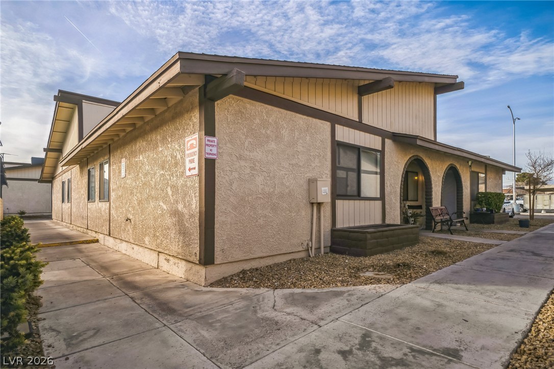 5733 Smoke Ranch Road, Unit D Las Vegas, NV 89108 - Photo 12 of 14 View of property exterior featuring covered porch and stucco siding