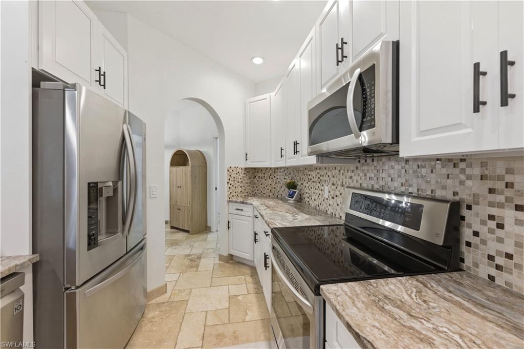 415 Crossfield Circle, Unit 81 Naples, FL 34104 - Photo 14 of 33 a kitchen with stainless steel appliances granite countertop a refrigerator and a stove top oven