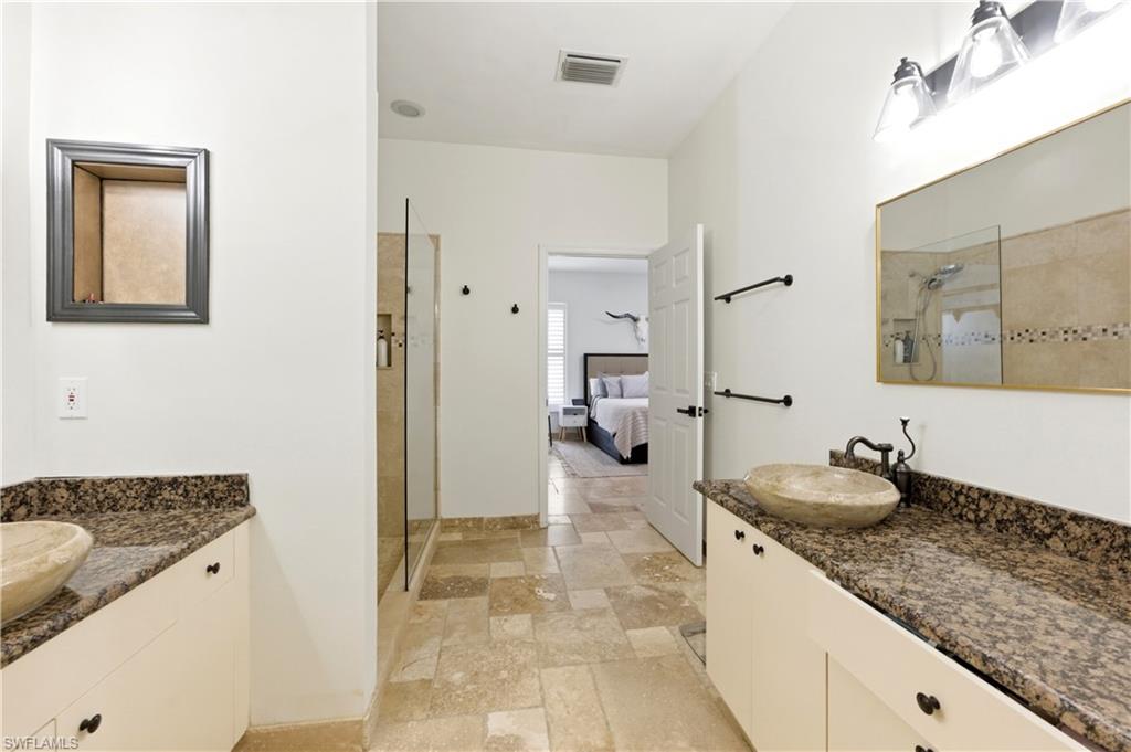 415 Crossfield Circle, Unit 81 Naples, FL 34104 - Photo 16 of 33 a bathroom with a granite countertop sink and a mirror