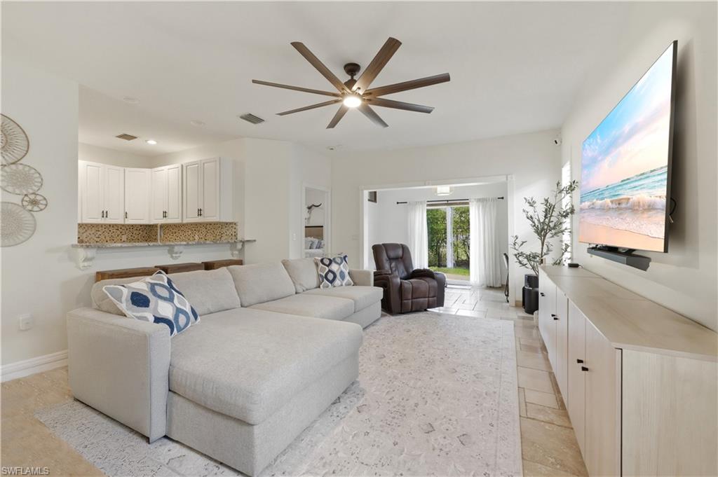 415 Crossfield Circle, Unit 81 Naples, FL 34104 - Photo 2 of 33 a living room with furniture a ceiling fan and a flat screen tv
