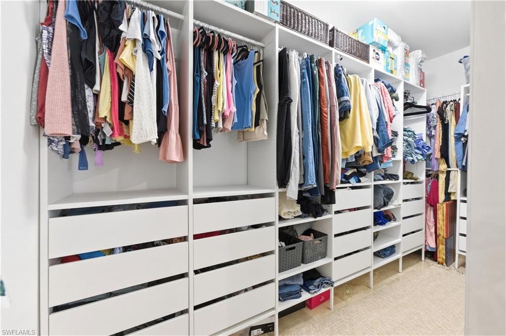 415 Crossfield Circle, Unit 81 Naples, FL 34104 - Photo 28 of 33 a view of walk in closet with clothes and shoes