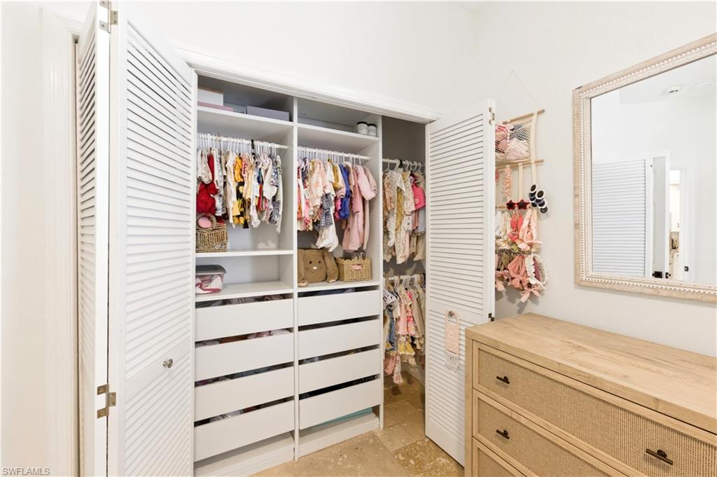 415 Crossfield Circle, Unit 81 Naples, FL 34104 - Photo 30 of 33 a view of walk in closet with clothes and shoes