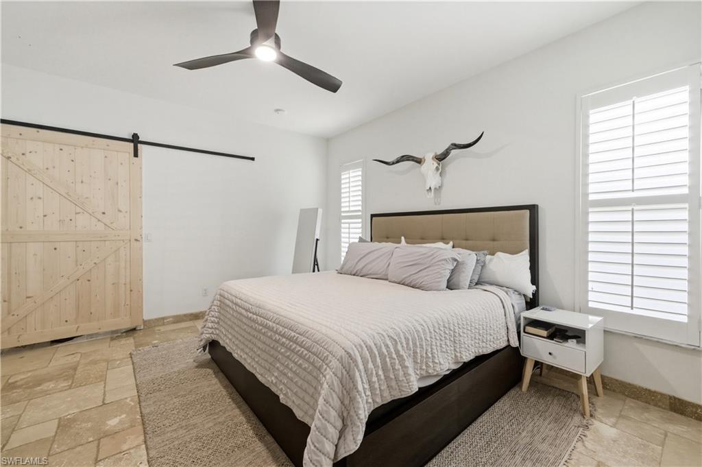 415 Crossfield Circle, Unit 81 Naples, FL 34104 - Photo 5 of 33 a bedroom with a bed and a chandelier