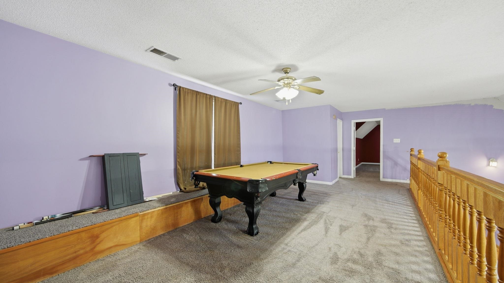 217 Rae Drive Munford, TN 38058 - Photo 29 of 40 Carpeted upper-level bonus room featuring lavender walls, a ceiling fan, and light wood railing