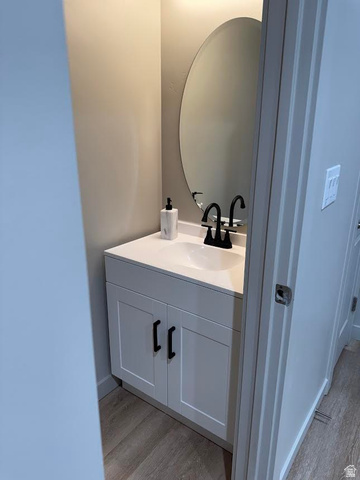 1787 North 1280 East Payson, UT 84651 - Photo 8 of 22 Vanity area featuring a white cabinet base, single-basin sink, black faucet, and an oval mirror