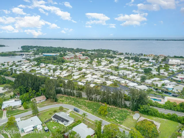 an aerial view of residential houses with outdoor space and trees