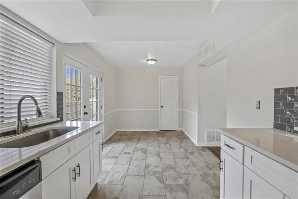 a kitchen with granite countertop a sink stove and cabinets