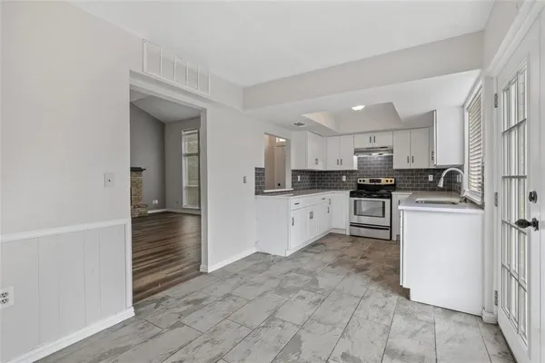 a kitchen with white cabinets and white appliances