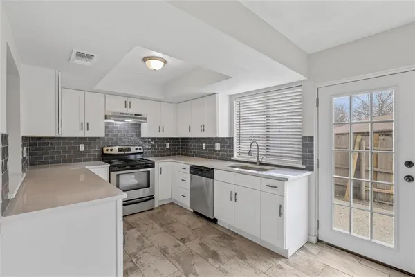 a kitchen with white cabinets and white appliances