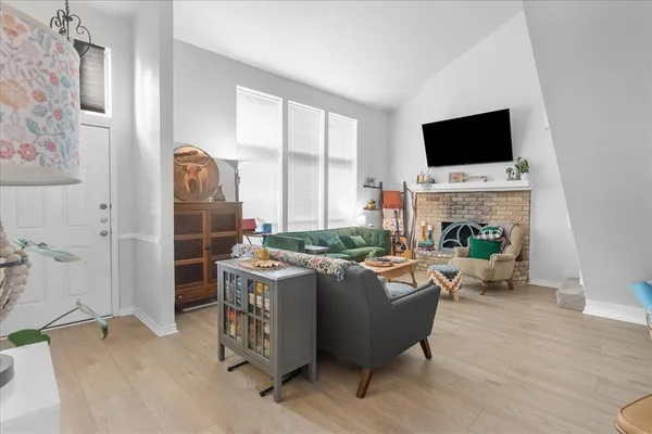 a living room with furniture a flat screen tv and a fireplace