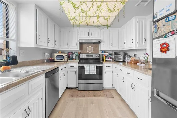 a kitchen with stainless steel appliances granite countertop a stove and cabinets