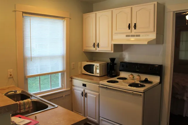 a kitchen with granite countertop a sink stove and cabinets