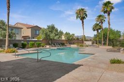 7701 West Robindale Road, Unit 277 Las Vegas, NV 89113 - Photo 31 of 33 An inviting community pool with lush palm trees offers a tranquil desert oasis.