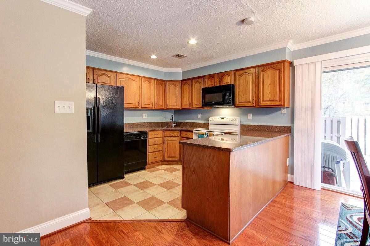 2299 White Cornus Lane Reston, VA 20191 - Photo 22 of 24 a kitchen with stainless steel appliances granite countertop a refrigerator a sink a stove a microwave and cabinets