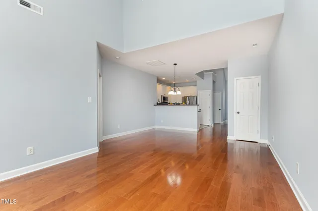 a view of empty room with wooden floor