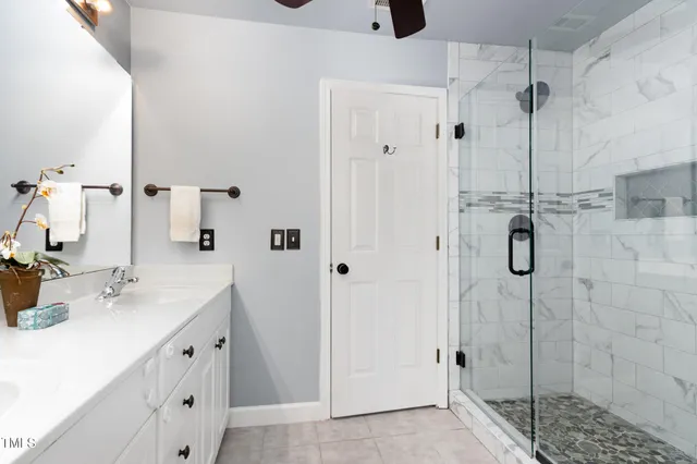 a bathroom with a double vanity sink mirror and shower