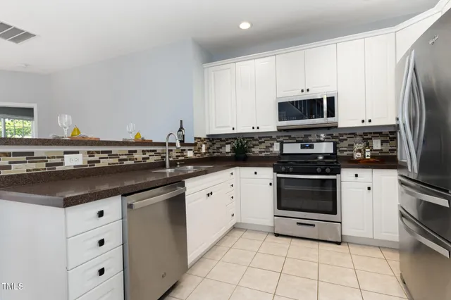 a kitchen with white cabinets and appliances