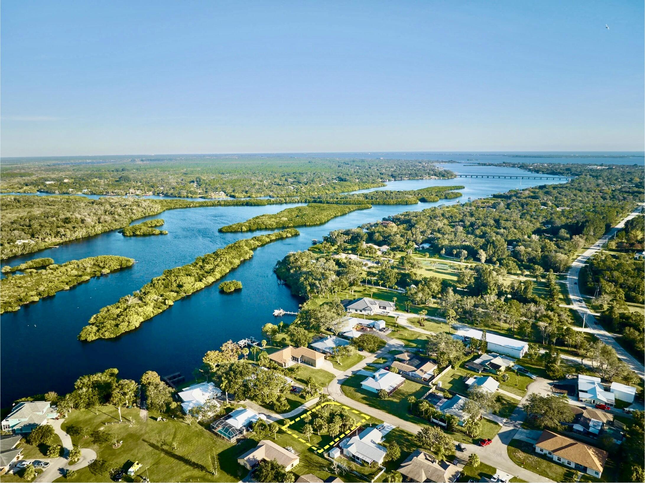 an aerial view of ocean and residential houses with outdoor space