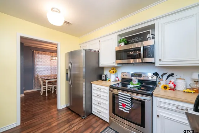 a kitchen with stainless steel appliances granite countertop a refrigerator microwave and stove top oven