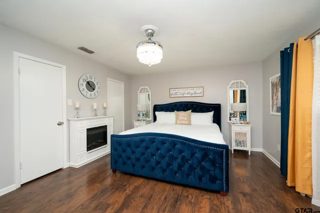 a spacious bedroom with a bed and wooden floor