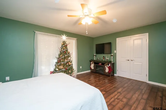 a bedroom with a bed and a flat tv screen on dresser