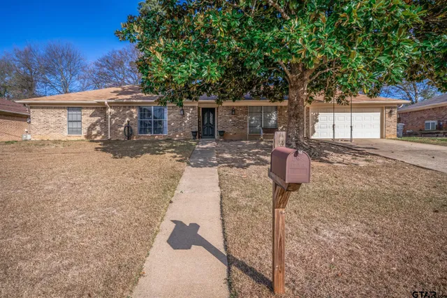 a front view of a house with yard tree and wooden fence