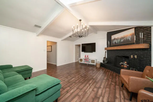 a living room with furniture a flat screen tv and a fireplace