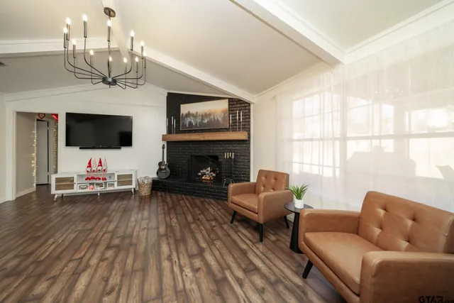 a living room with furniture a flat screen tv and a fireplace