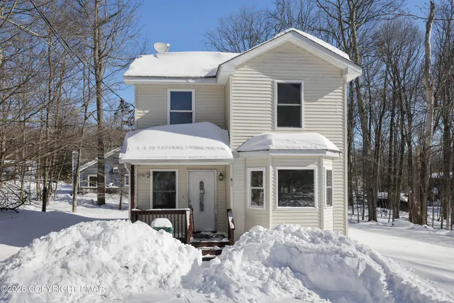 a view of a white house with a large windows and large tree