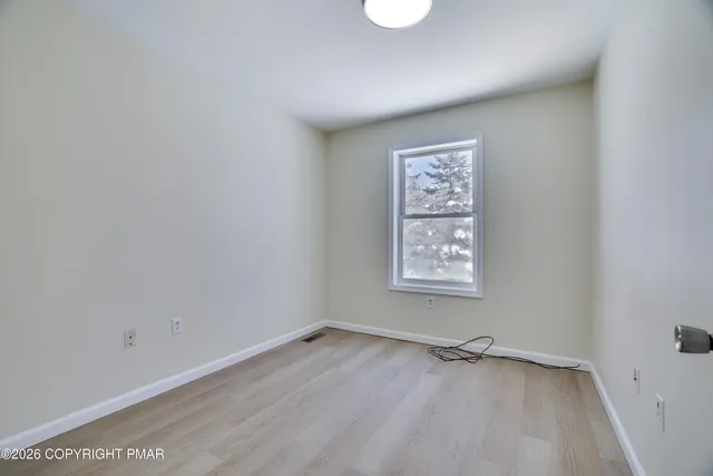a view of an empty room and wooden floor