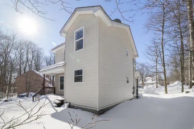 a view of a white house with a snow on the road
