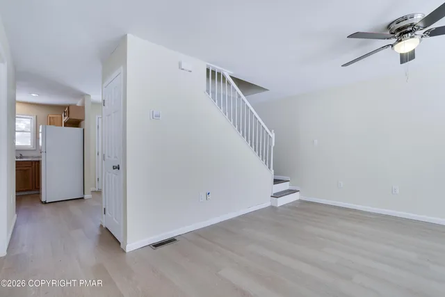 a view of hallway with stairs and wooden floor