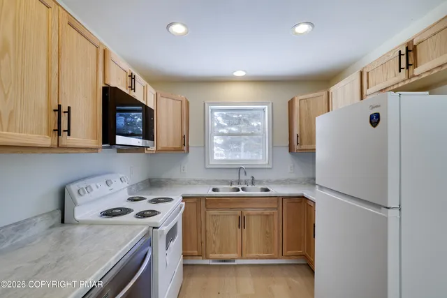 a kitchen with a white stove top oven and refrigerator
