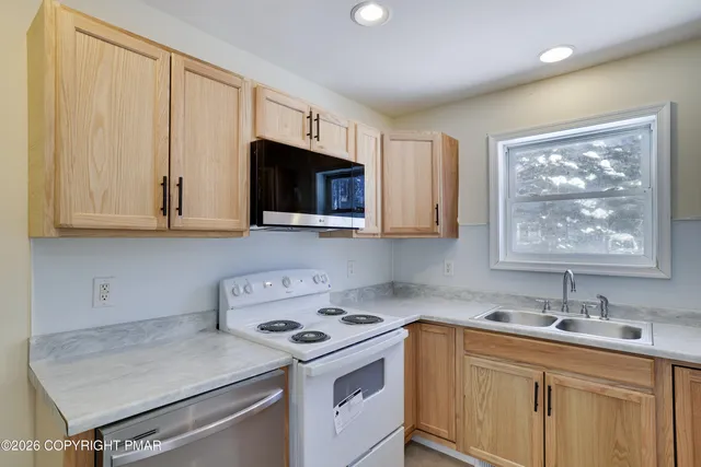 a kitchen with a sink stove and microwave