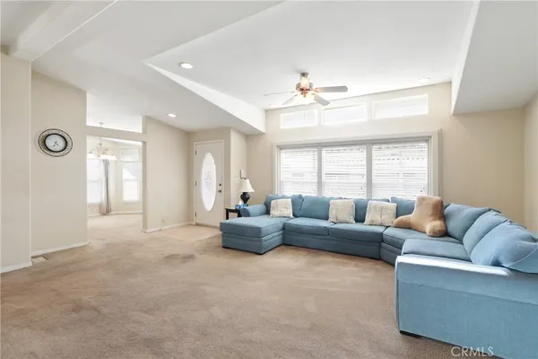 a living room with furniture a ceiling fan and a window
