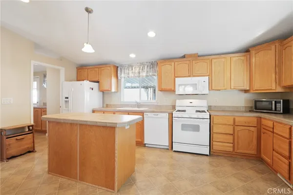 a kitchen with stainless steel appliances kitchen island granite countertop a sink stove and refrigerator