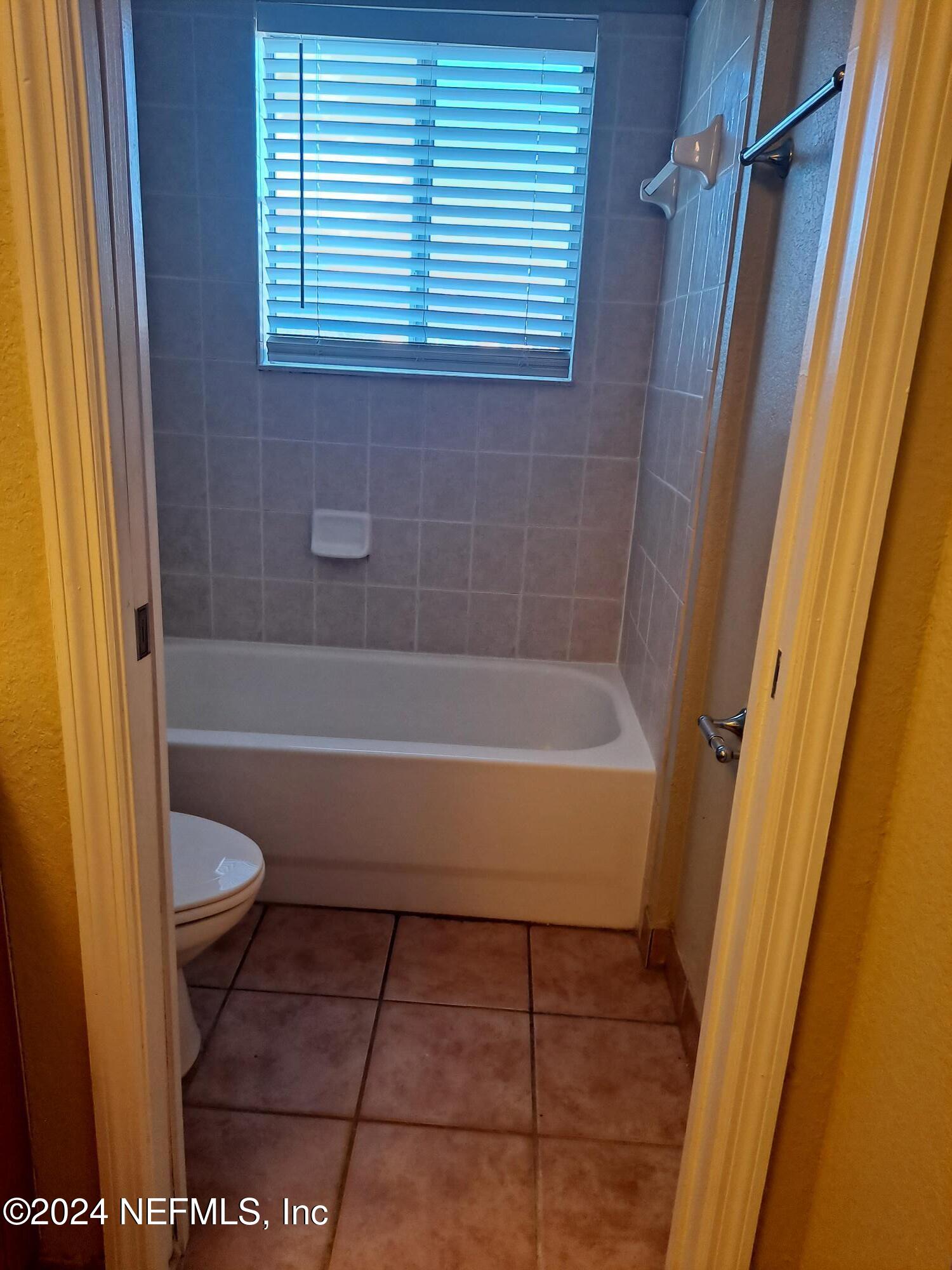 9745 Touchton Road, Unit 927 Jacksonville, FL 32246 - Photo 18 of 22 a bathroom with a granite countertop bathtub and toilet