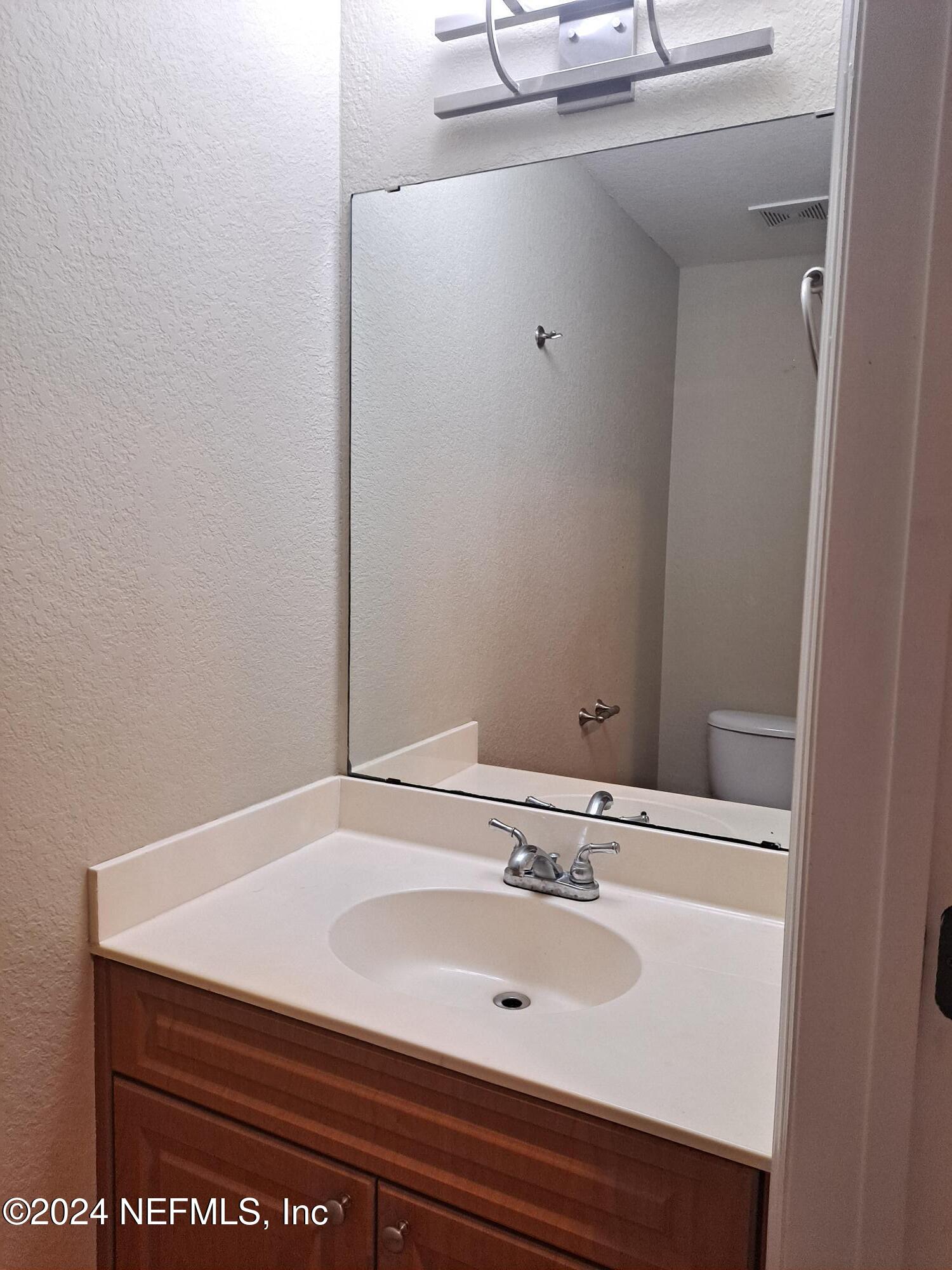 9745 Touchton Road, Unit 927 Jacksonville, FL 32246 - Photo 2 of 22 a bathroom with a sink and a mirror