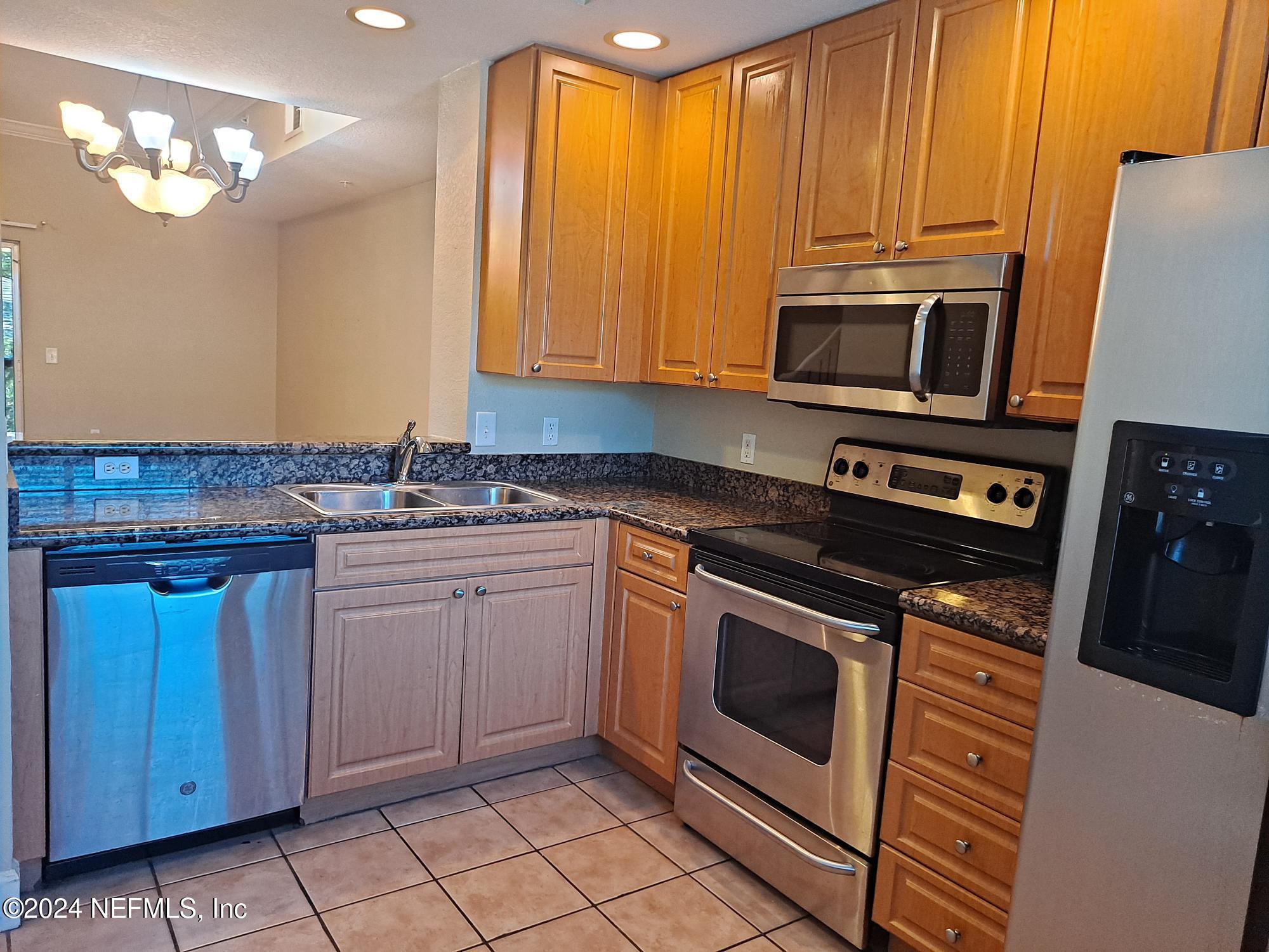9745 Touchton Road, Unit 927 Jacksonville, FL 32246 - Photo 3 of 22 a kitchen with stainless steel appliances granite countertop a stove microwave and cabinets