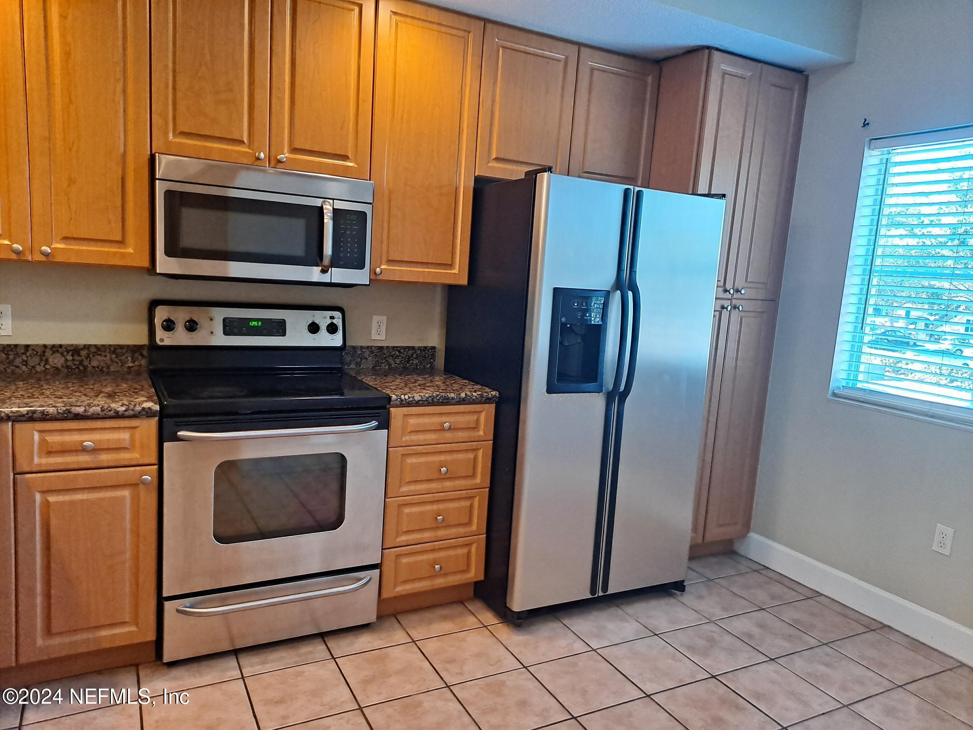 9745 Touchton Road, Unit 927 Jacksonville, FL 32246 - Photo 4 of 22 a kitchen with stainless steel appliances granite countertop a refrigerator stove and microwave