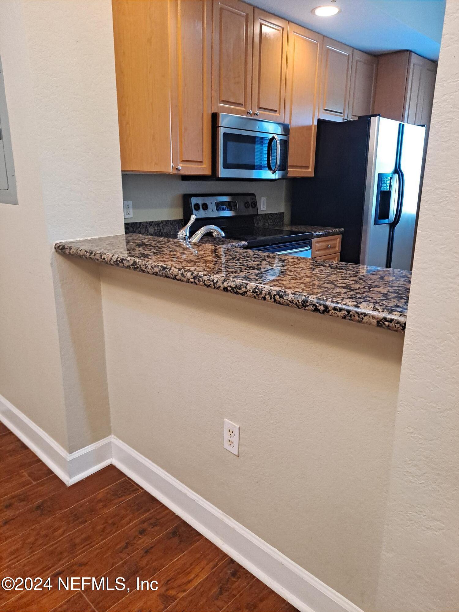9745 Touchton Road, Unit 927 Jacksonville, FL 32246 - Photo 7 of 22 a kitchen with granite countertop cabinets and steel stainless steel appliances