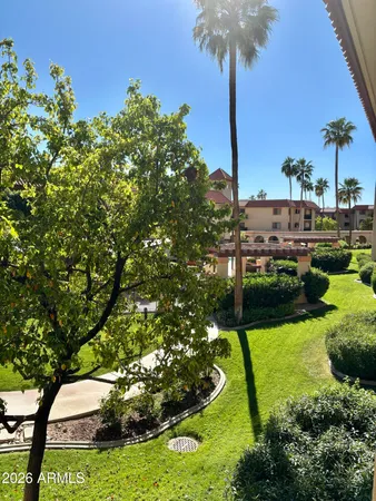a view of a street with a bench and cars park side of the road