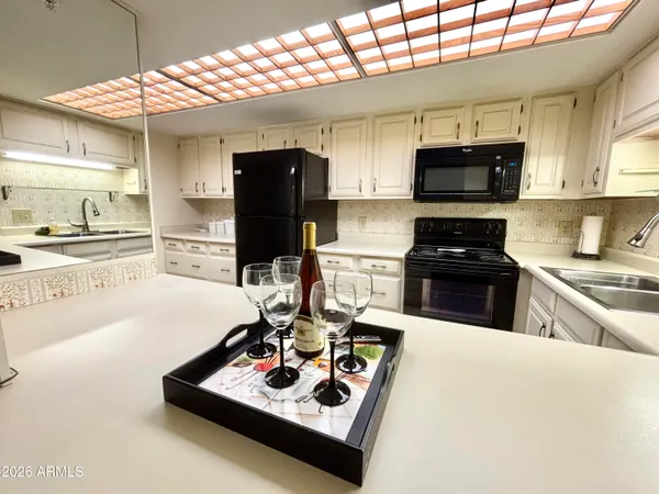 a kitchen with stainless steel appliances kitchen island granite countertop a sink stove and refrigerator
