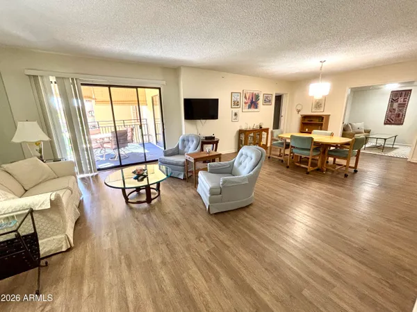a living room with furniture and a flat screen tv with wooden floor