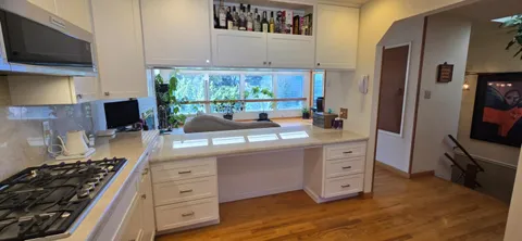 a kitchen with stainless steel appliances granite countertop a stove a sink and a microwave