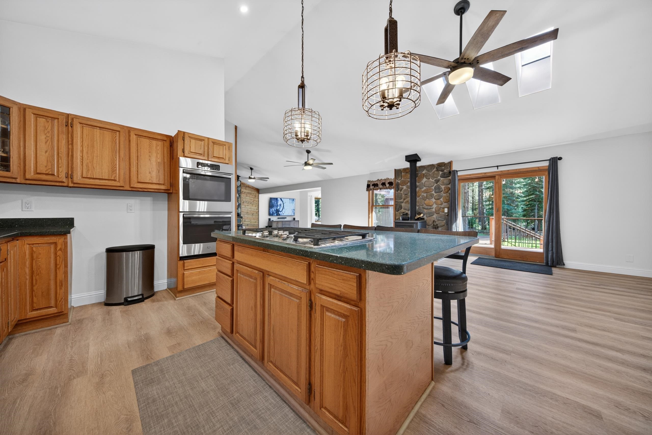 463-000 Moonlight Ranch Rd Westwood Road Susanville, CA 96130 - Photo 7 of 46 a kitchen with stainless steel appliances granite countertop a stove top oven a refrigerator a dining table and chairs with wooden floor