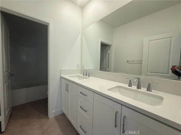 a white bath tub sitting next to a white toilet and vanity