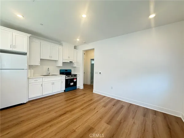 a kitchen with stainless steel appliances granite countertop a refrigerator and a stove top oven