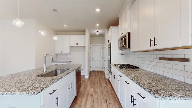 a kitchen with granite countertop a sink stove and cabinets