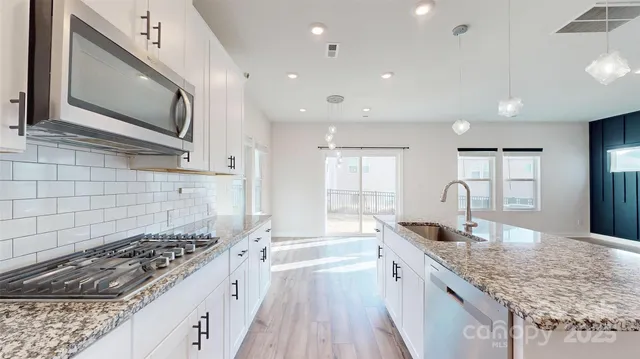 a kitchen with stainless steel appliances granite countertop a sink stove and cabinets